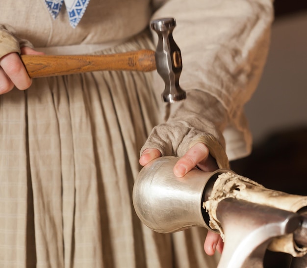 Lady hammering silver mug