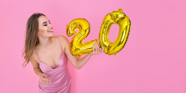 Lady holds foil balloons in the form of numbers  twenty percent discounts sales and cashback