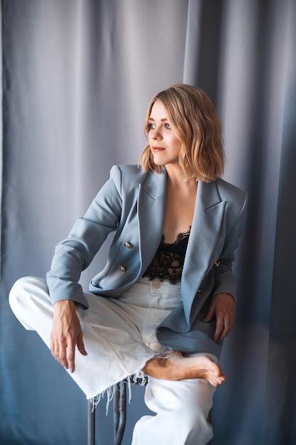 Lady in jeans daydreaming while sitting with ankle on knee