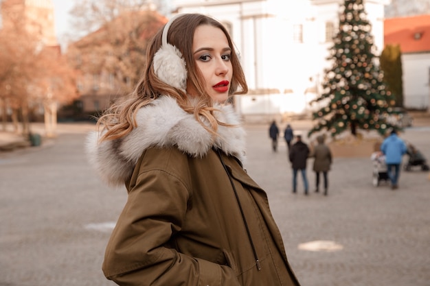 Lady in a knitted sweater and fluffy headphones