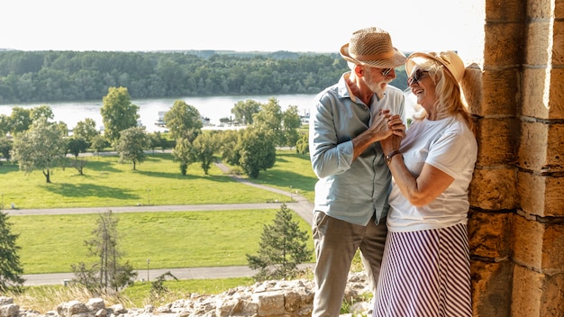 Foto signora appoggiata a un muro sorridendo a un uomo