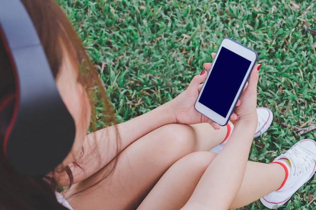 lady listening music from smart phone with headphones