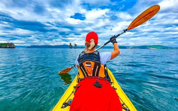 Lady paddling the kayak in the Avacha bay