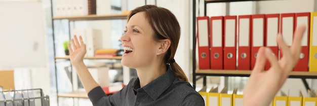 Lady secretaris voelt zich blij om een lange werkdag op kantoor af te ronden. gelukkige vrouw in donker shirt