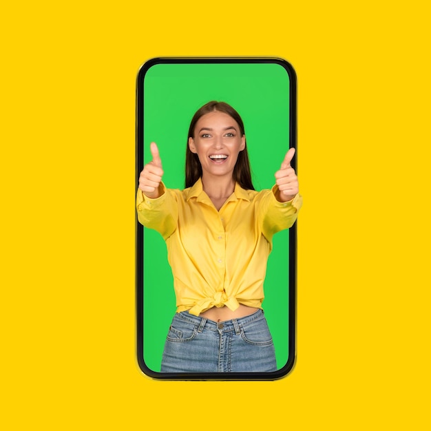 Lady in smartphone screen gesturing thumbs up over yellow background