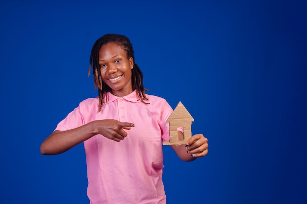 Lady smiling as she points to a house