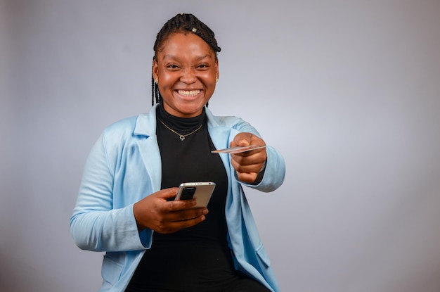 Lady smiling operating her phone giving out her credit card