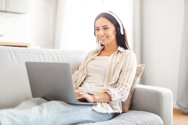 Lady on sofa working with laptop at home