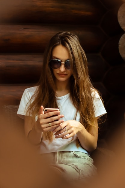 lady in sunglasses at the wooden house posing