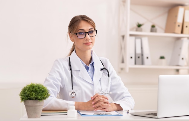 lady therapist sitting looking at camera in modern clinic office