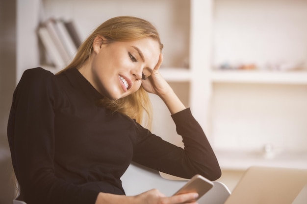 Signora che utilizza smartphone e laptop