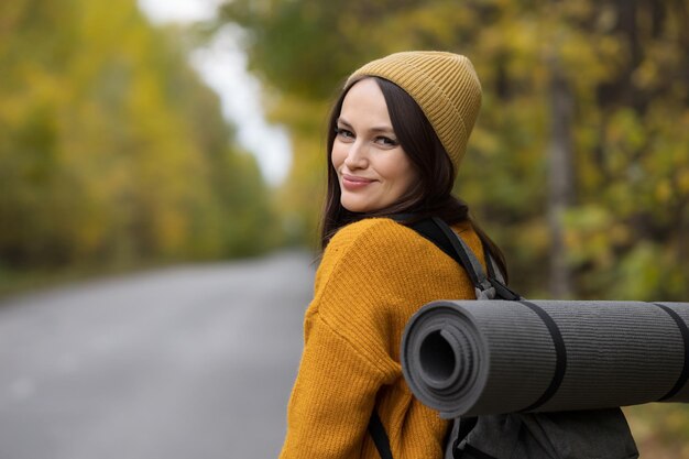 女性は世界中のヒッチハイク旅行に行く車を待っています