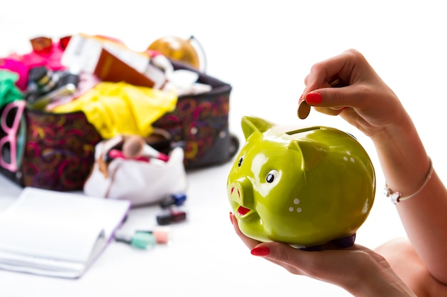 Ladys hand with piggy bank coin and lime money box the most expensive trip make savings for the future