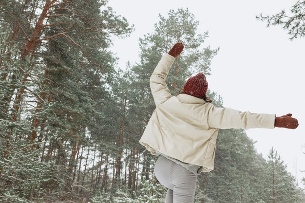 Lage hoek achteraanzicht van onherkenbare gelukkige vrouw springen met opgeheven armen