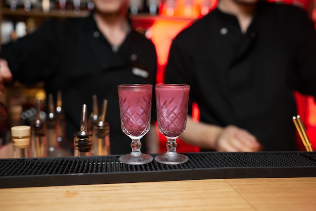 Lage hoek close-up van een gastronomische mixdrank cocktail van zoete roze limonade wodka en gin martini gar