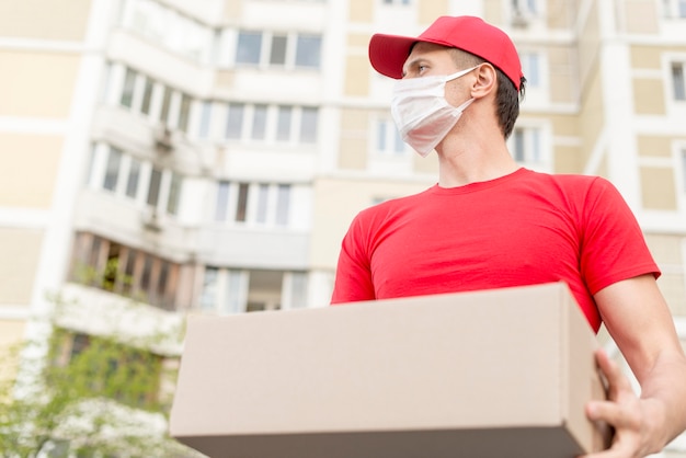 Foto lage hoek levering man met chirurgisch masker