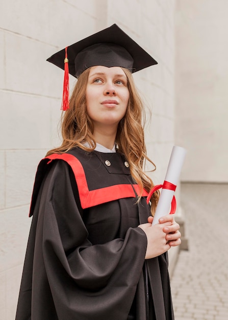 Foto lage hoek meisje met diploma