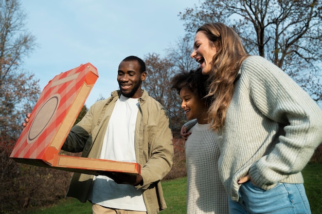 Lage hoek smileyvrienden met pizzadoos