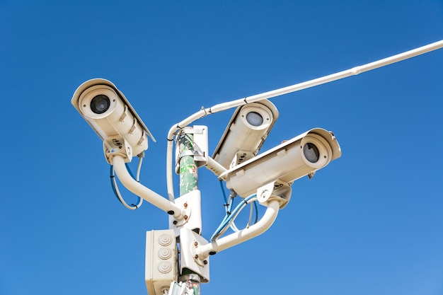 Lage hoek van beveiligingscamera's tegen een heldere blauwe lucht