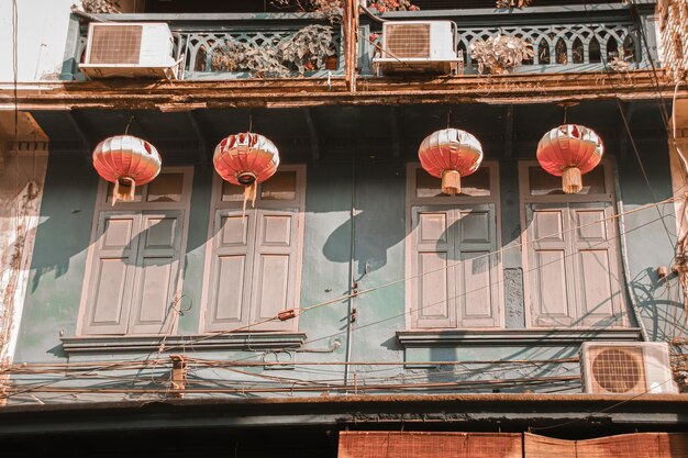 Foto lage hoek van chinese lantaarns die buiten het oude gebouw hangen