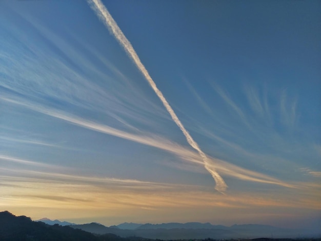 Foto lage hoek van dampsporen in de lucht tijdens zonsondergang