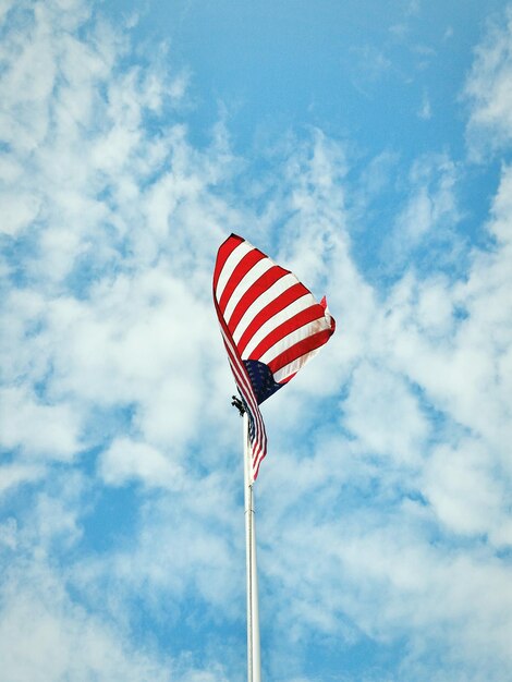 Lage hoek van de Amerikaanse vlag die tegen de blauwe hemel zwaait