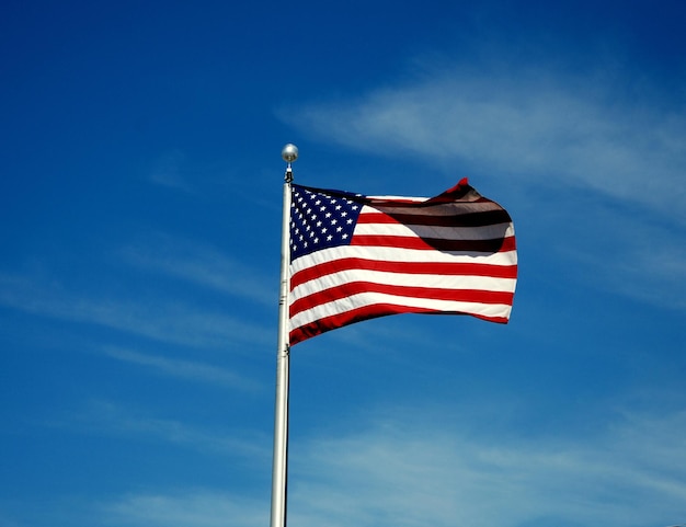 Lage hoek van de Amerikaanse vlag die tegen de lucht zwaait
