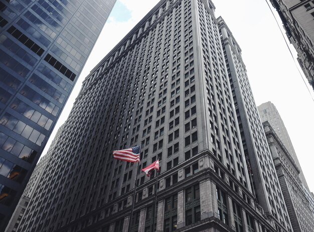 Foto lage hoek van de amerikaanse vlag te midden van gebouwen in de stad