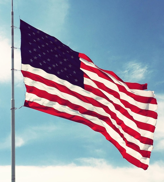 Lage hoek van de Amerikaanse vlag tegen de blauwe hemel
