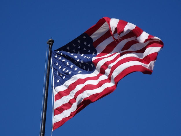 Lage hoek van de Amerikaanse vlag tegen een heldere blauwe hemel