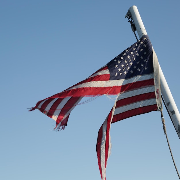 Lage hoek van de Amerikaanse vlag tegen een heldere blauwe hemel