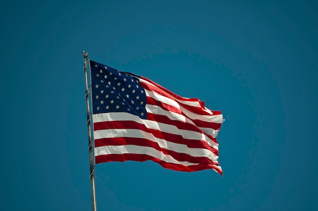 Lage hoek van de Amerikaanse vlag tegen een heldere blauwe hemel