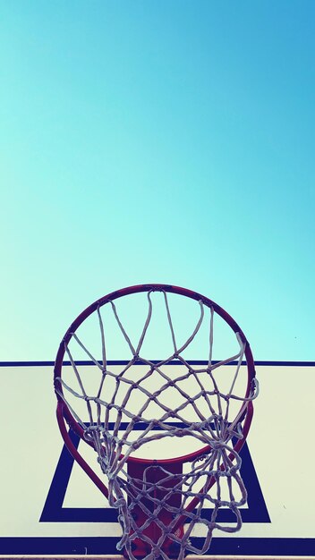Lage hoek van de basketbalhoep tegen een heldere blauwe lucht