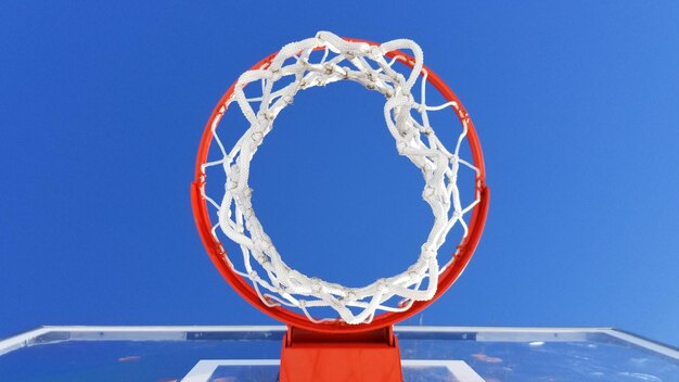 Foto lage hoek van de basketbalhoep tegen een heldere blauwe lucht