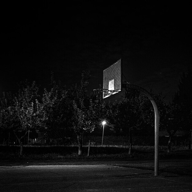 Foto lage hoek van de basketbalhoepel op de speeltuin's nachts