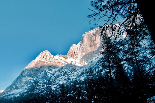 Foto lage hoek van de besneeuwde berg tegen een heldere blauwe hemel