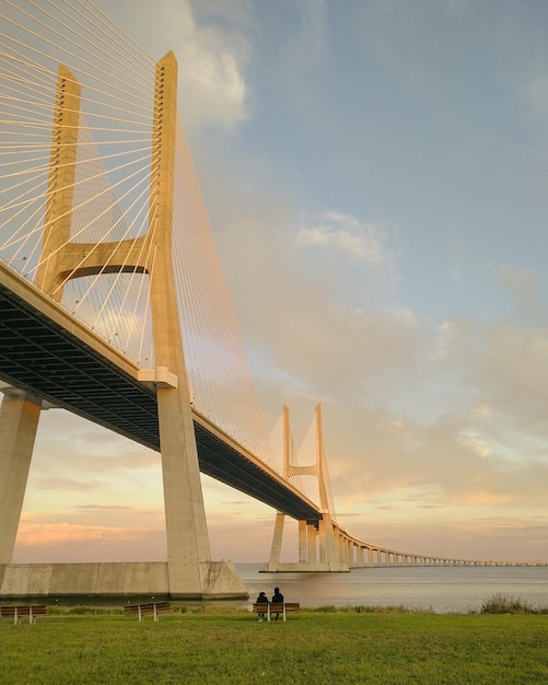 Foto lage hoek van de brug over de zee tegen de hemel tijdens de zonsondergang