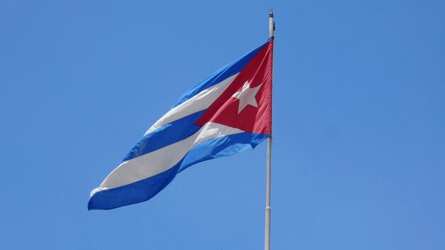 Lage hoek van de Cubaanse vlag tegen een heldere blauwe hemel