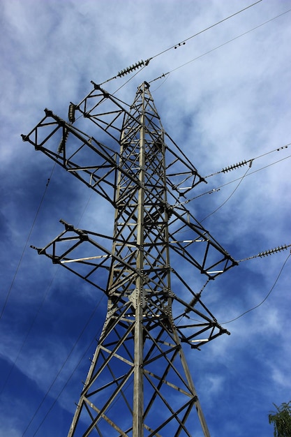 Foto lage hoek van de elektriciteitspylon tegen bewolkte lucht