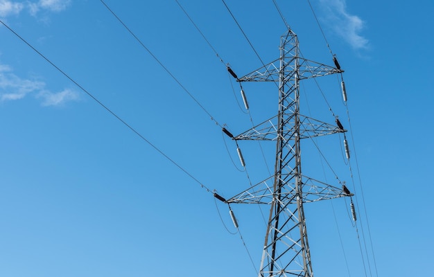 Lage hoek van de elektriciteitspylon tegen de blauwe hemel