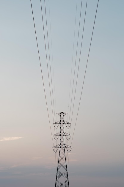 Lage hoek van de elektriciteitspylon tegen de hemel tijdens de zonsondergang