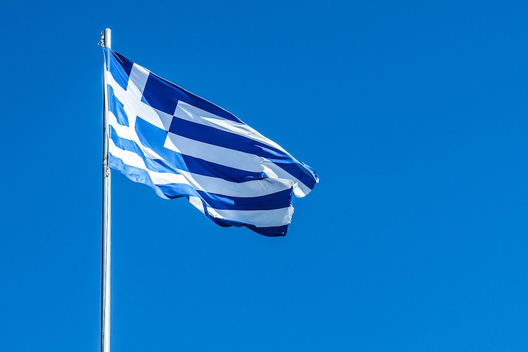 Foto lage hoek van de griekse vlag tegen een heldere blauwe hemel