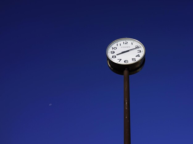 Foto lage hoek van de klok tegen een heldere blauwe hemel