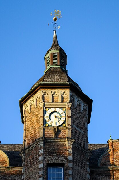 Foto lage hoek van de klokkentoren tegen een heldere blauwe hemel