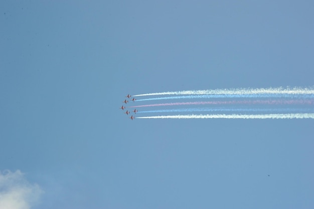 Lage hoek van de luchtshow tegen de heldere blauwe hemel rode pijlen