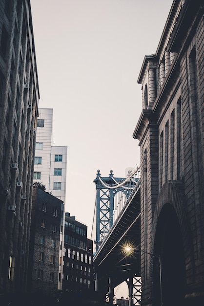 Lage hoek van de manhattan bridge door gebouwen tegen de lucht