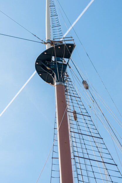 Foto lage hoek van de mast van het schip tegen een heldere blauwe hemel