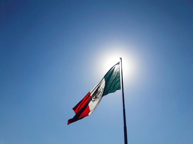 Lage hoek van de Mexicaanse vlag tegen een heldere blauwe lucht