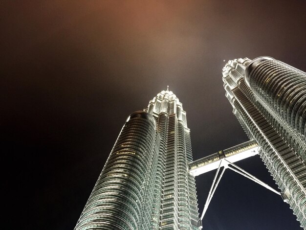 Foto lage hoek van de petronas torens tegen de hemel in de stad 's nachts