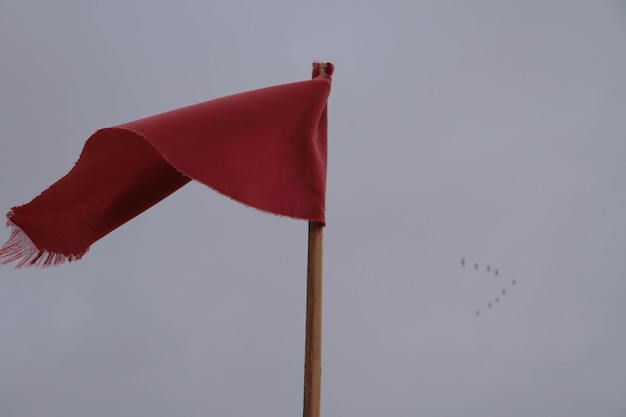 Lage hoek van de rode vlag tegen de hemel